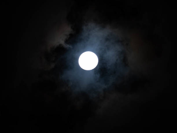 Full moon shining on cloudy night sky background. Beauty in nature