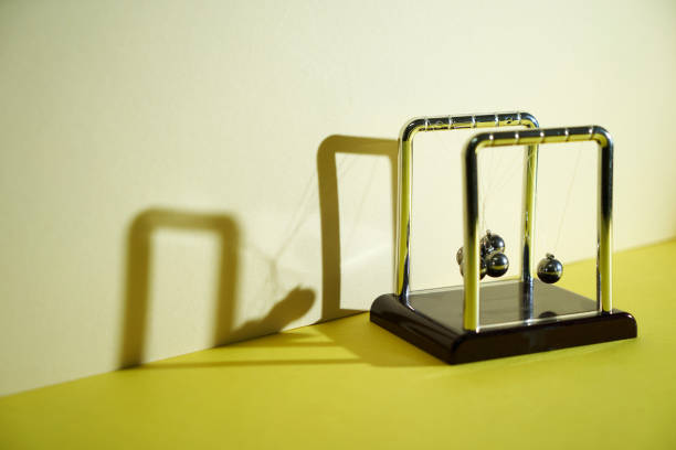 istock close up newton pendulum tangled against yellow background 2190181857