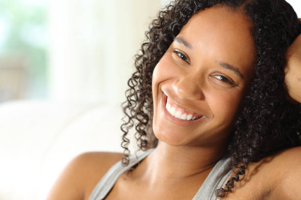 Portrait of a happy black woman with perfect smile posing at home stock photo