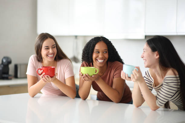 istock Three women talking and laughing in the kitchen 2190182749