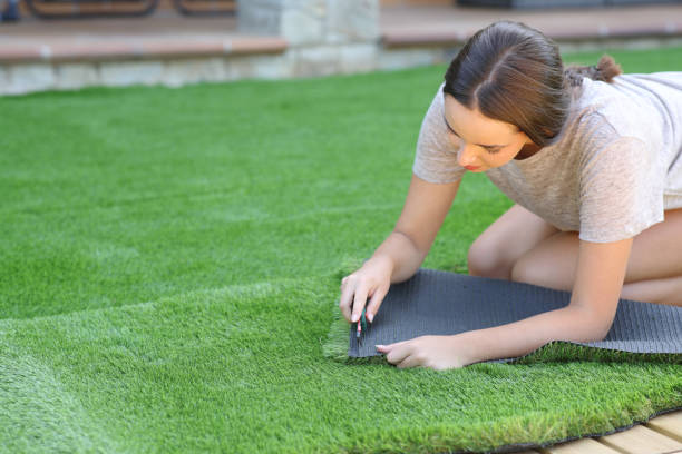 istock Woman cutting and installing artificial lawn 2190183197