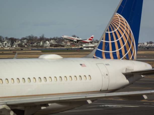 Boston, United States – January 04, 2024: United Airlines plane at Boston Logan Airport with American Airlines TWA livery in background