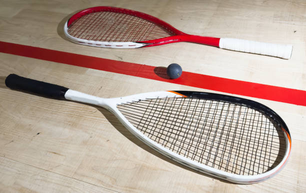 istock Two rackets and two squash balls lie on the parquet floor. Horizontal photo 2190186612
