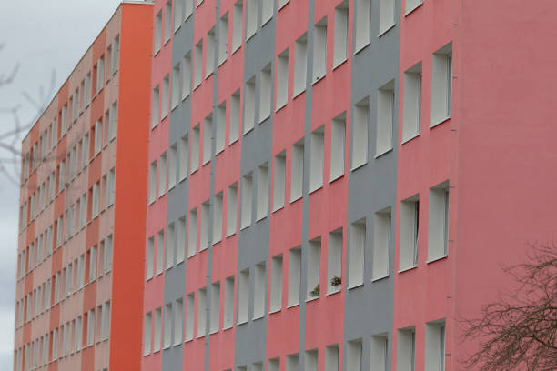 The structure features striking red and gray exteriors, complemented by numerous large windows adorning its facade, giving it a modern appeal