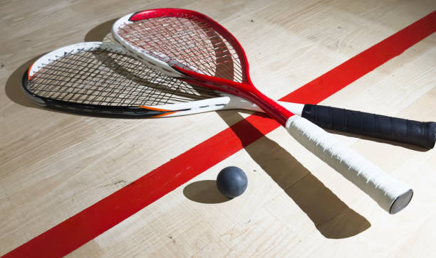 istock Two rackets and two squash balls lie on the parquet floor. Horizontal photo 2190189037
