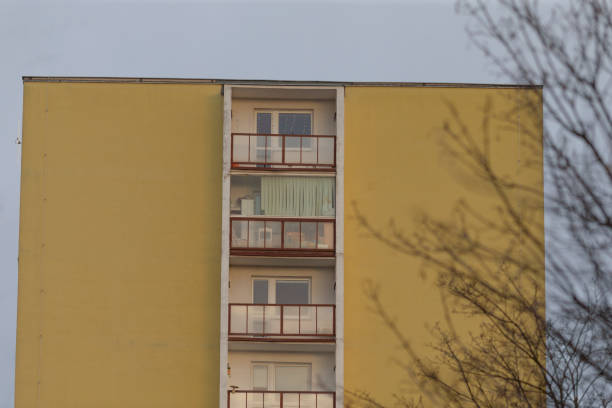 istock A bright yellow building featuring balconies and a tree in the background 2190189691