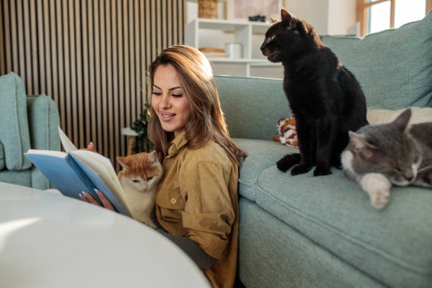 istock Young woman reading a book while spending time with her pets 2190190848