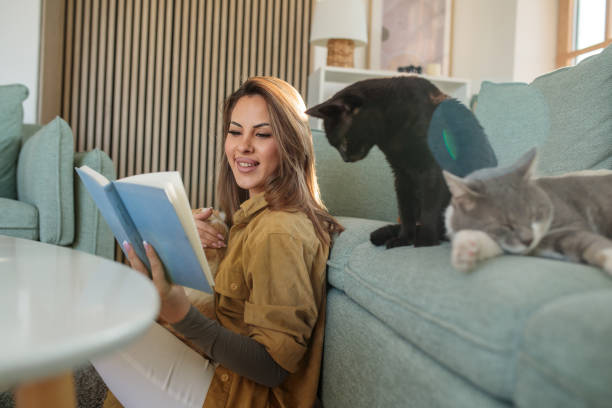 istock Young woman reading a book while spending time with her pets 2190190866