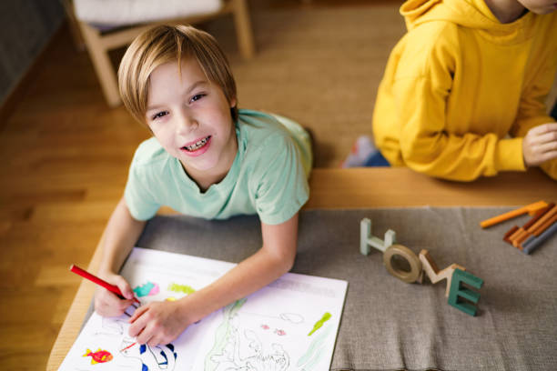 istock A boy is coloring in a coloring book 2190191596