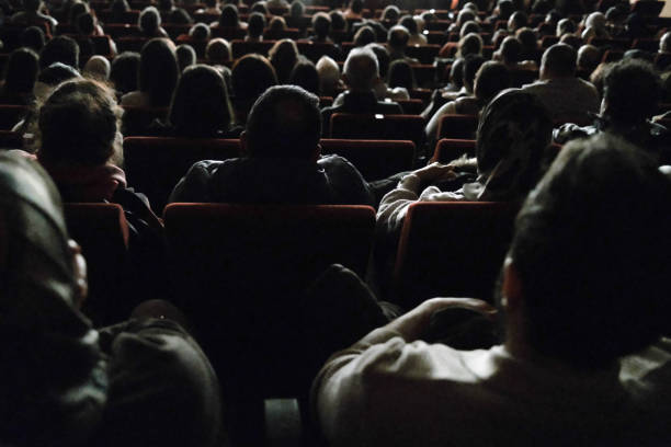 Man closing red front curtains in theatre, closeup