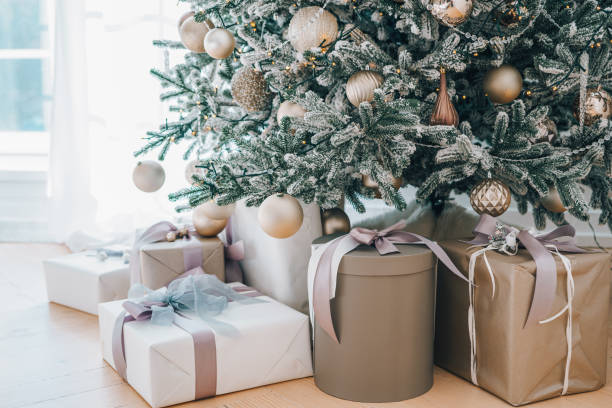 istock Decorated Christmas tree with frosted branches and wrapped presents, gift boxes it in living room 2190193448