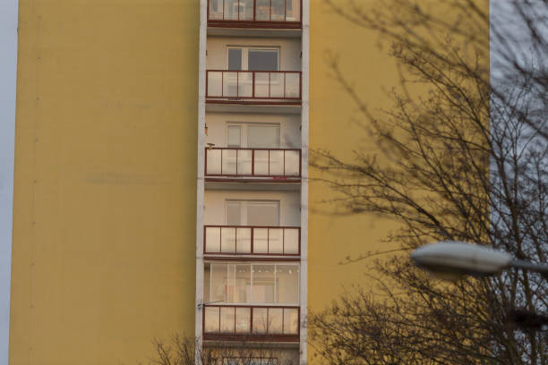 A yellow building with balconies and a streetlight in front
