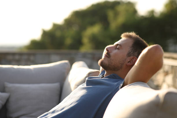 istock Relaxed man resting sitting on an exterior sofa in terrace 2190196060