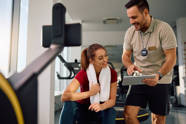 istock Happy sportswoman and her personal coach using touchpad during exercise class in a gym. 2190201670