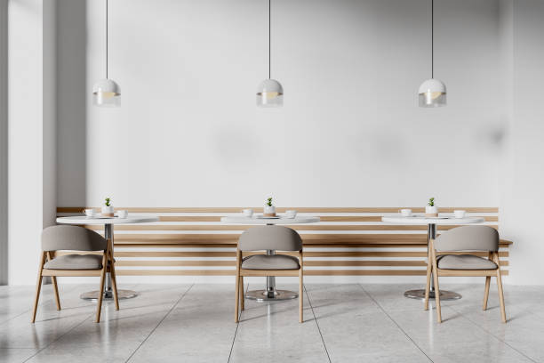 istock Minimalist cafe interior featuring modern chairs, round tables, and pendant lights. Neutral tones on a sleek, contemporary background. 3D Rendering 2190202851