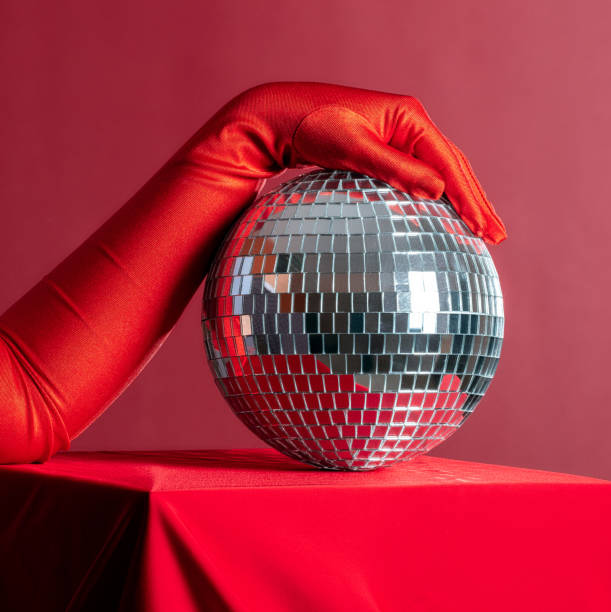 istock A woman's hand in a red glove holds a disco ball on a red background 2190203972