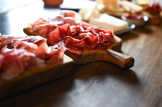 beef bresaola and ham on cutting board.