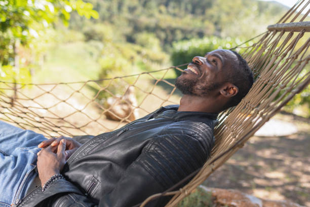 istock Man enjoying a glamping getaway, smiling wide while relaxing in a hammock 2190205812