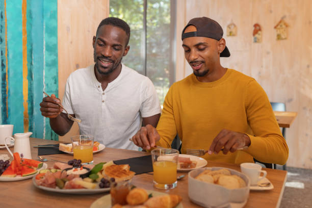 istock Two men having breakfast, tasting fresh fruit and vegetables, enjoying food 2190205876