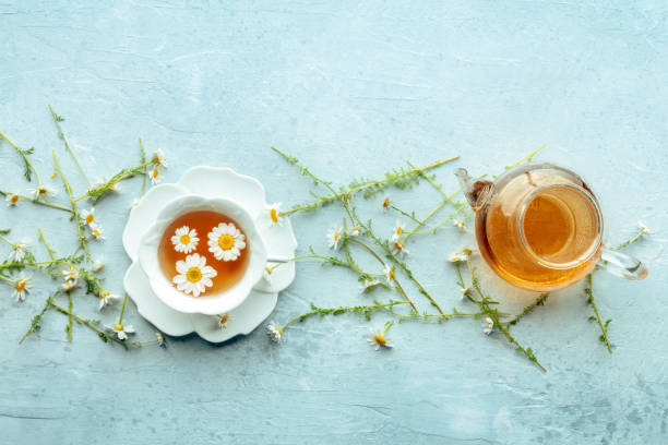 istock Chamomile flower tea. A tea cup and a tea pot with fresh medicinal flowers 2190206603