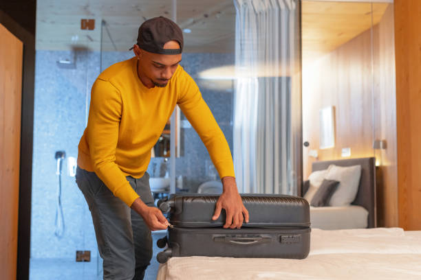istock Man packing a suitcase in a hotel room, getting ready for a departure 2190206736