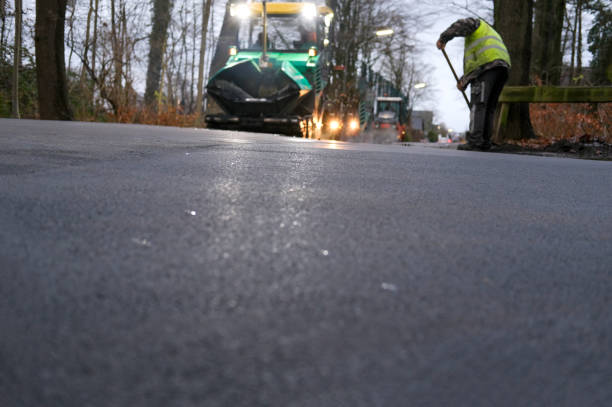 istock Road Construction at Night  Asphalt Paving with Construction Workers in Protective Gear and Machinery in the Dark, much Copy Space 2190206824