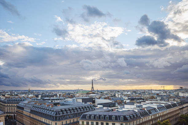 Townscape with old and modern architecture, the Eiffel Tower at distance under the overcast at sunset in Paris, France