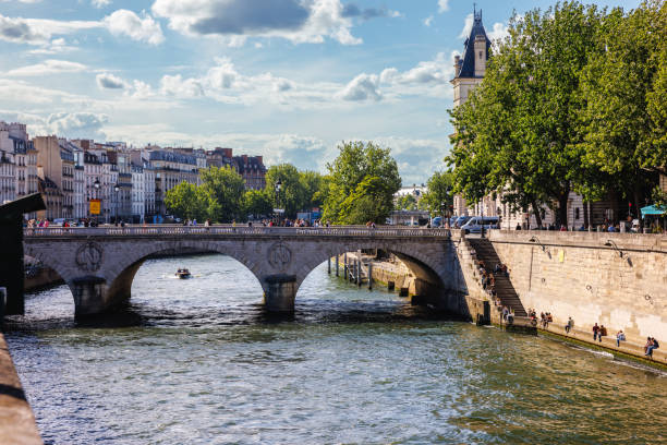 Paris, France, June 7, 2022: People walking on Pont Neuf and resting on the embankment at the River Seine in Paris, France