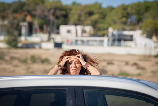 istock Sad woman taking a break with her car during a coastline trip . 2190212052