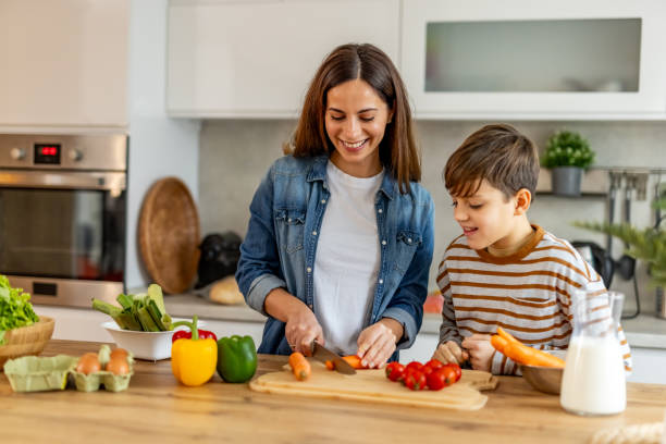 istock Mother and son bonding over cooking a nutritious meal with fresh vegetables in a contemporary kitchen 2190213022