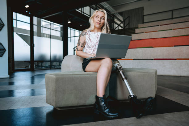 istock Woman with prosthetic leg working on laptop 2190213785