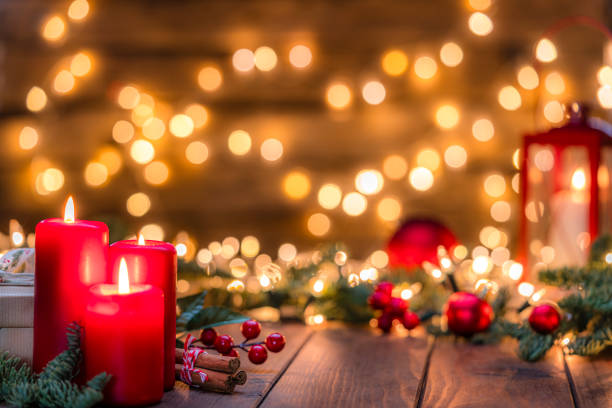istock Three burning Christmas decore candles on rustic wooden table 2190215863
