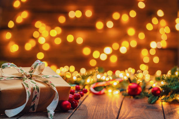 istock Christmas present on a cozy table with defocused Christmas lights at background 2190215884