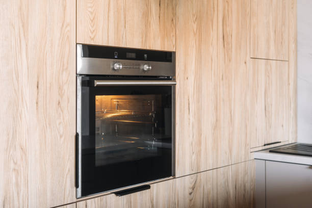 istock Modern kitchen featuring sleek black oven with wooden cabinetry design 2190216048