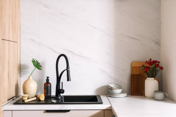 istock Modern kitchen sink with black faucet featuring decorative plants and dishware 2190216051