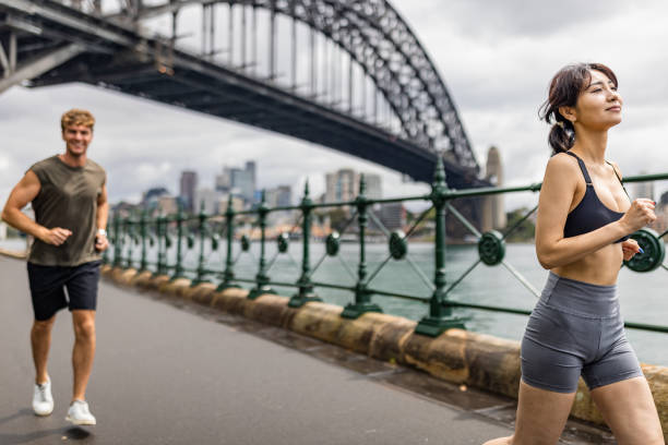 istock Two people jogging by Sydney Harbour Bridge in an urban environment 2190221028