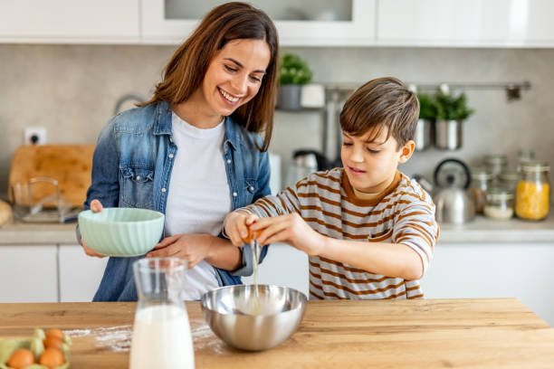 istock Joyous mother and son bonding in the kitchen as they bake, crack eggs, and make cherished memories together 2190221236