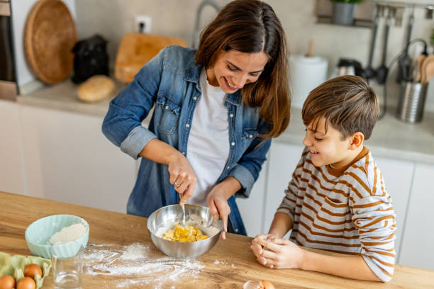 istock Mother and son bonding while baking a cake in their contemporary kitchen, creating cherished family memories 2190221388