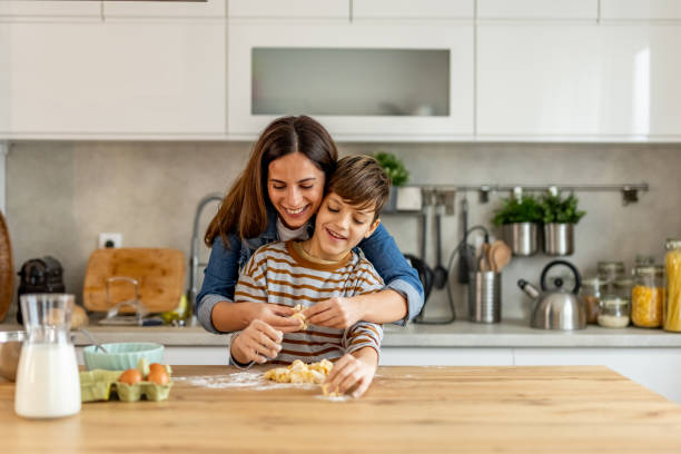 istock Mother and son bonding while cooking and baking together in their modern, sunny kitchen 2190221512