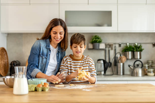 istock Mother and son happily making cookie dough together in a contemporary kitchen 2190221572