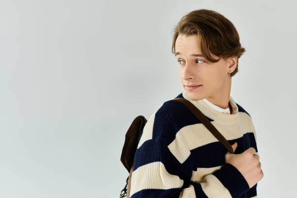 istock Stylish young man in college outfit poses confidently in studio environment 2190223233