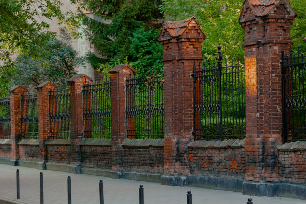 istock aged fence brick pillars architecture form along pavement old rustic common Europe city street outdoor garden 2190224097