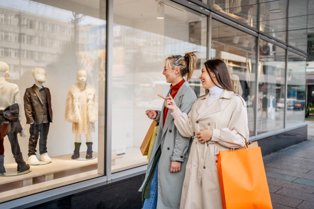 istock Female friends looking at store window 2190224606