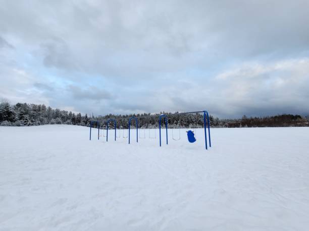 istock Snowy playground with blue swings in winter. 2190224682