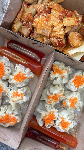 Chicken feet siomai and chili sauce fill takeout containers.