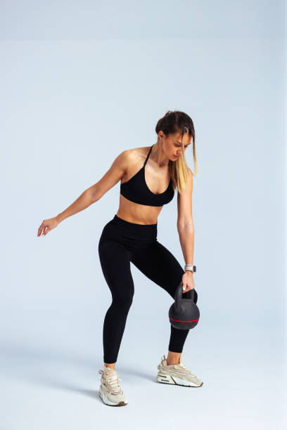 istock Young athletic woman performing kettlebell swing exercise 2190228652