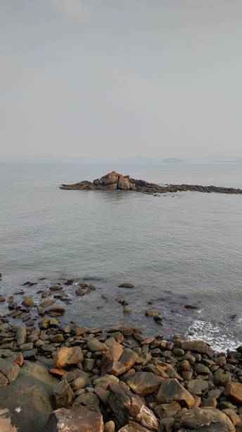 istock Serene coastal scene with rocky shores and distant island. 2190228990
