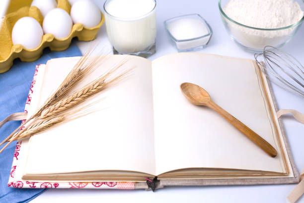 Empty recipe book and baking ingredients on the table. Cooking process. Close-up.