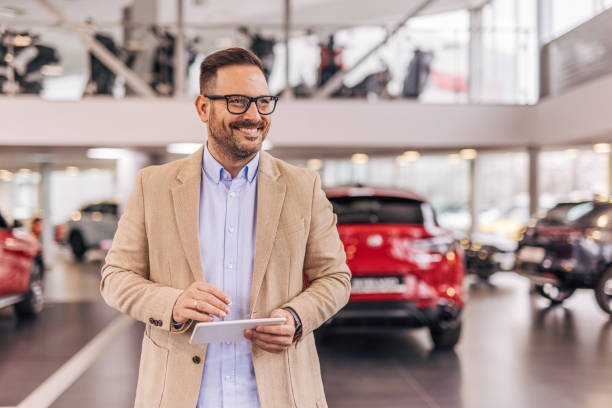 istock Car salesman with tablet in showroom 2190231922