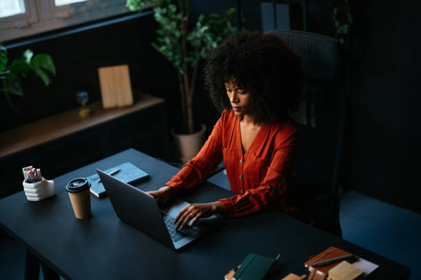 istock Young businesswoman working late at night in a modern office using a laptop 2190232073